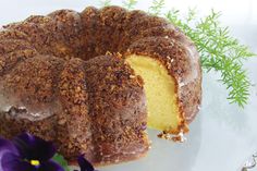 a bundt cake on a plate with purple flowers