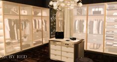 an image of a dressing room setting with clothes on racks and chandelier hanging from the ceiling