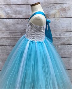 This adorable and beautiful Frozen themed Elsa inspired tutu dress is hand-made by Stella with full of love and affection and is perfect for your lovely girl for her birthday, Halloween Party, being a flower girl, for the wedding party, being bridesmaid, for the christening, or any other special occasion. The dress features 6-inch-long soft white crochet decorated with sparkly rhinestones and beautiful metallic silver rick rack trimming covering the top edge. The combination of aqua blue and gli Light Blue Sleeveless Birthday Dress, Light Blue Sleeveless Dress For Birthday, Cute Blue Tutu Dress For Dress-up, Sleeveless Blue Birthday Dress, Light Blue Princess Tutu Dress For Birthday, Cute Blue Tutu Dress For Birthday, Cute Blue Princess Dress For Pageant, Cute Blue Princess Dress For Pageants, Princess Birthday Party Outfit