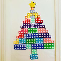 a colorful christmas tree made out of legos on a white door with a star above it