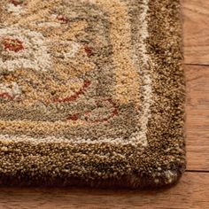 a close up of a rug on the floor with wood floors in the foreground