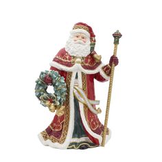 a santa clause figurine holding a staff and wreath on it's side