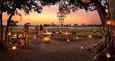 a group of people standing next to each other under a tree with lanterns hanging from it