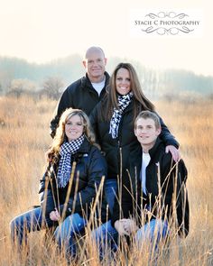 a family poses for a photo in the tall grass