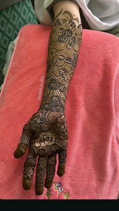 a woman's hand with henna tattoos on her left arm and the top part of her hands