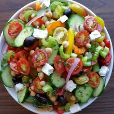 a salad with tomatoes, cucumbers, chickpeas and olives