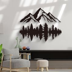 a living room with a chair, table and wall hangings that have mountains on them