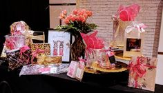 a table topped with lots of different types of gift bags and flowers in vases