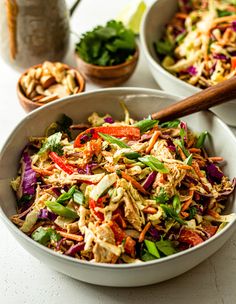 two white bowls filled with salad on top of a table