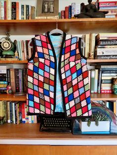 "Amazing, wonderfully colorful and chaotic handmade women's harlequin vest, circa 1970s! The patchwork fabrics are mainly a mix of thick double knit polyester prints and colors with lots of texture and body. The vest is lined in a silky print acetate in a swirly blue and orange print. There are elaborate overlays of black rick rack trim over the seams of where the patchwork pieces meet, and the edges are bound with black grosgrain ribbon trim. This was definitely handmade and was done nicely! Th Multicolor Patchwork Fitted Vest, Fitted Multicolor Patchwork Vest, Retro Multicolor Sleeveless Vest, Multicolor Fitted Winter Vest, Fitted Multicolor Sweater Vest For Winter, Fitted Multicolor Vest For Winter, Winter Multicolor Fitted Vest, Retro Patchwork Vest For Fall, Fitted Multicolor Vintage Vest