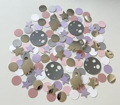 a pile of different colored and shaped confetti on top of a white table