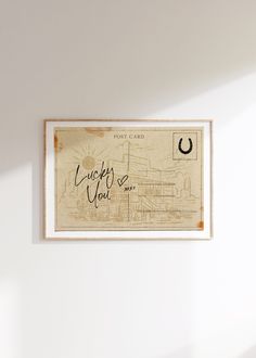 a framed poster hanging on the wall above a bed in a room with white walls