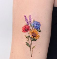 a woman's arm with flowers and leaves on the left side of her body