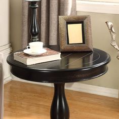 a black table with a white coffee cup on it and a framed picture next to it