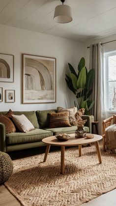 a living room with green couches and pictures on the wall above them, along with rugs