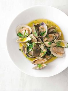 a white bowl filled with clams and sauce