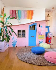 a child's playroom with pink, blue and green furniture on the floor