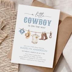 a little cowboy is on the way baby shower card with clothes hanging from a line