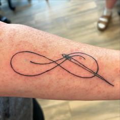 a tattoo with an infinite symbol on the arm