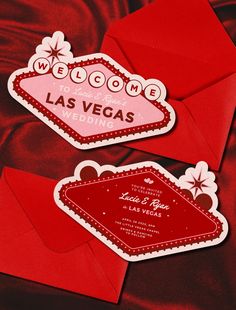 two red envelopes with the word welcome to las vegas printed on them, sitting next to each other