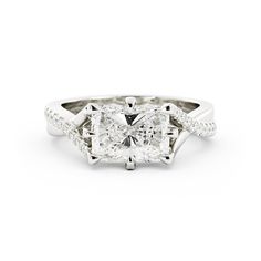 a cushion cut diamond engagement ring with twisted shans on the sides and an intricate band