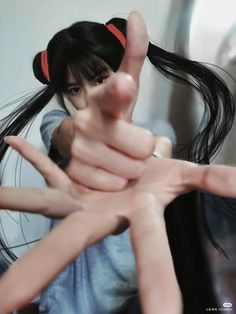 a woman with long black hair holding her hands out