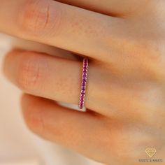 a woman's hand with a pink diamond ring