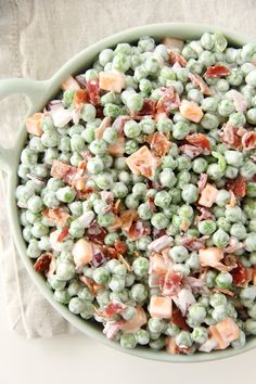 a green bowl filled with peas and bacon