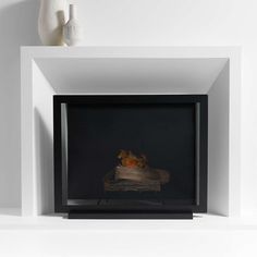 a white fireplace with a vase on top of it