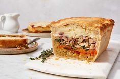 a piece of meat pie sitting on top of a cutting board next to a plate