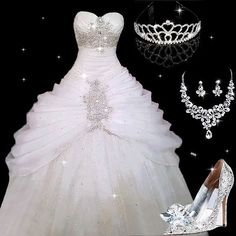 a white wedding dress and tiara on display in front of a black back ground