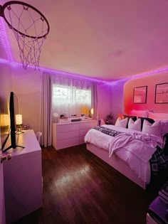 a bed room with a basketball hoop hanging from the ceiling and purple lights on the walls