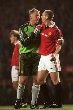 two men standing next to each other on a soccer field