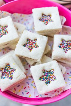 small white cakes with sprinkles in a pink bowl