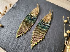 Statement earrings with long ombre fringes and detailed brass findings Color: brass with dark green to golden color gradient These large fringe earrings stand out immediately because of their finely worked brass findings and long ombre fringes. The color gradient is an irregular pattern which results in a more natural looking color transition and less like a structured color scheme. In addition differently colored beads were used to add more details to the fringe - either as little dots, embelli Ombre Fringe Earrings, Handwoven Earrings, Miyuki Delica Beads, Toho Beads, Earring Stand, Delica Beads, Beaded Fringe, Seed Bead Earrings, Fringe Earrings