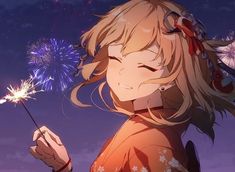 a girl holding a sparkler in her hand and looking at the sky with fireworks