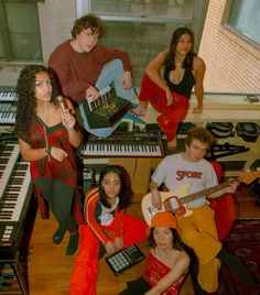 a group of young people sitting next to each other in front of a piano keyboard