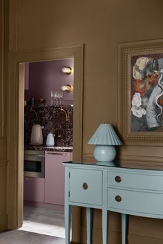 a blue table sitting in front of a painting on the wall