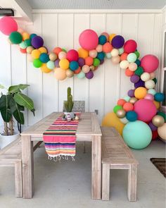 a table and bench with balloons on the wall