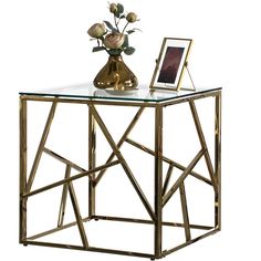 a glass and metal table with flowers on top, next to a framed photo frame