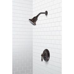 an image of a shower faucet with white tiles on the wall behind it