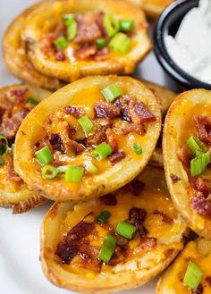 baked potato skins with bacon and green onions on a white plate, ready to be eaten