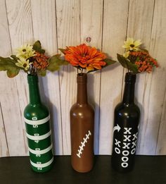 three vases with flowers in them sitting on a table