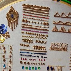 a close up of many different types of earrings on a white surface with gold trim