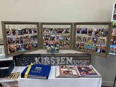 a table topped with pictures and books next to a white table cloth covered tablecloth