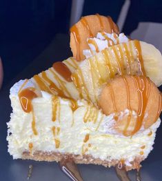 a piece of cheesecake with bananas and caramel drizzled on top