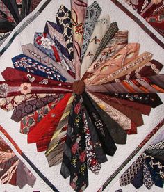 a bunch of ties laid out in a circle on top of a quilted surface