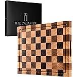 a wooden chess board with black and white squares on it, next to the company's logo