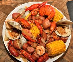 lobsters, corn on the cob and mussels in a white bowl