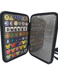 an open case with lots of different badges on the front and back of it's sides